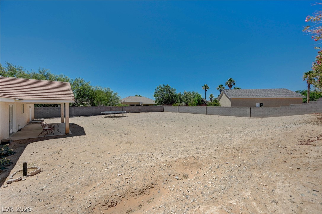 1272 Liston Avenue Logandale, NV 89021 - Photo 44 of 61 A spacious, bare yard awaits your landscaping vision, framed by a sturdy block wall and a covered patio.