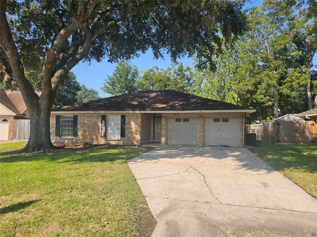 a front view of a house with a garden and trees
