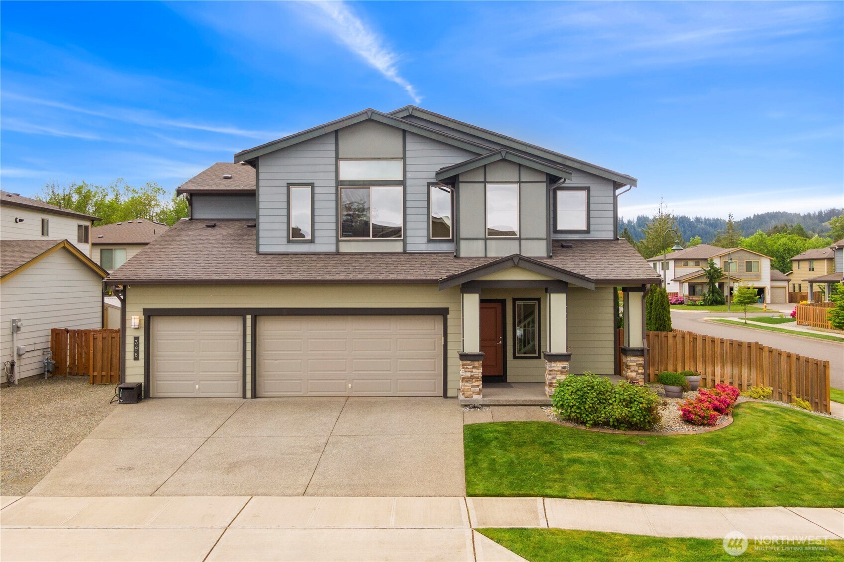 a front view of a house with a yard and potted plants