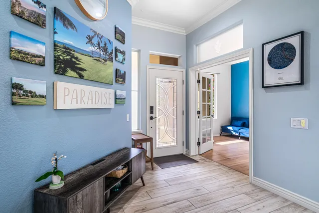 a hallway with a wooden floor and a potted plant