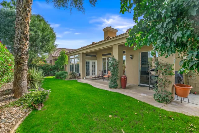 a view of a chair and table in backyard of the house