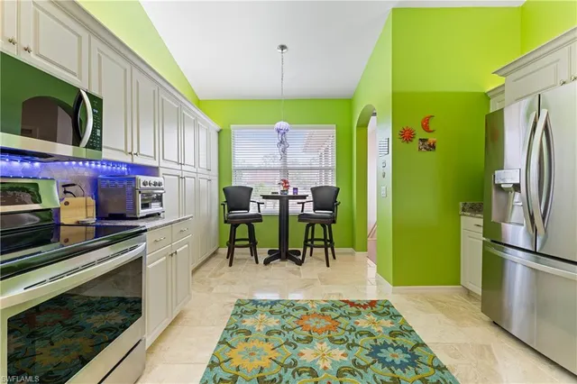 a kitchen with stainless steel appliances kitchen island granite countertop a refrigerator and a stove top oven