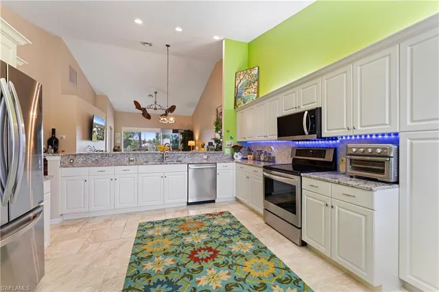 a kitchen with stainless steel appliances kitchen island granite countertop a stove a sink and a microwave