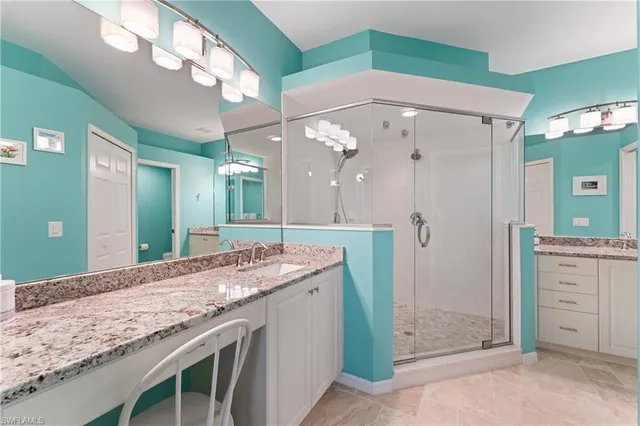 a bathroom with a granite countertop sink a mirror and a shower