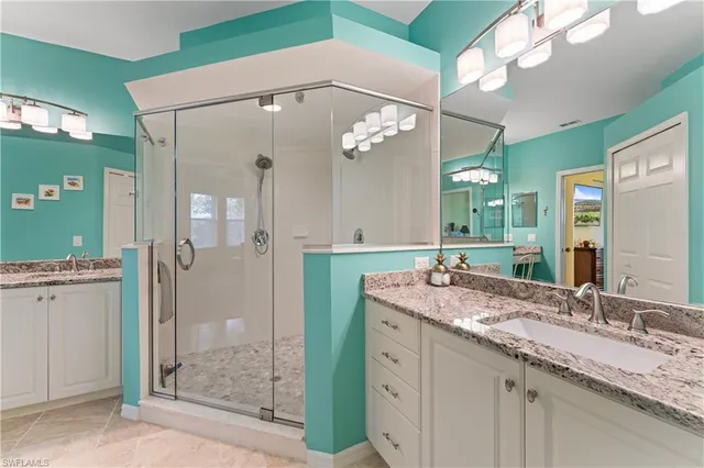 a bathroom with a granite countertop sink a mirror and shower