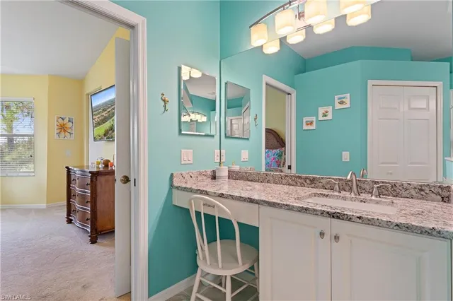 a en suite bathroom with a granite countertop sink and a mirror
