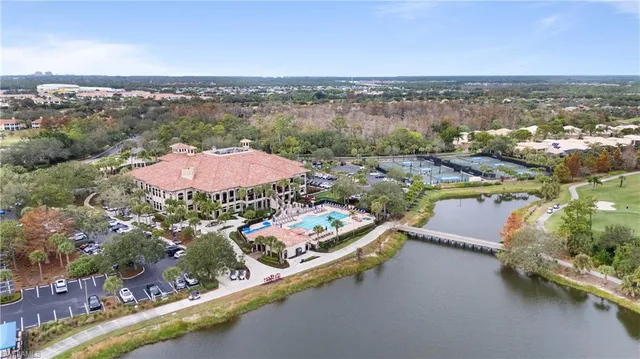 an aerial view of a city with lots of residential buildings and ocean view in back
