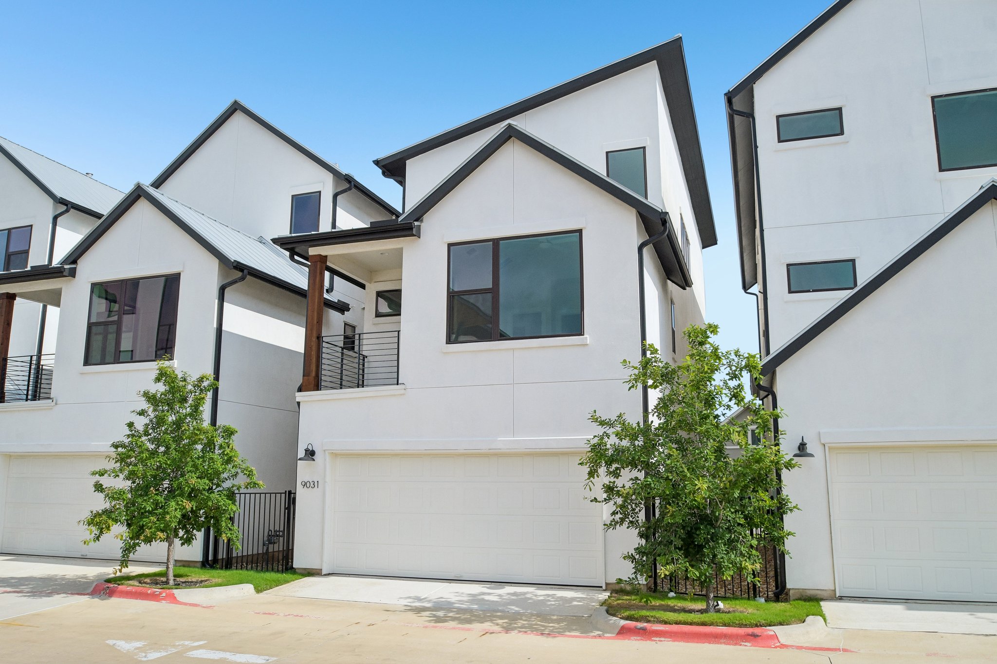 9031 Cattle Baron Path Austin, TX 78747 - Photo 28 of 31 Modern townhome exterior with crisp white stucco and striking black trim offers refined curb appeal.