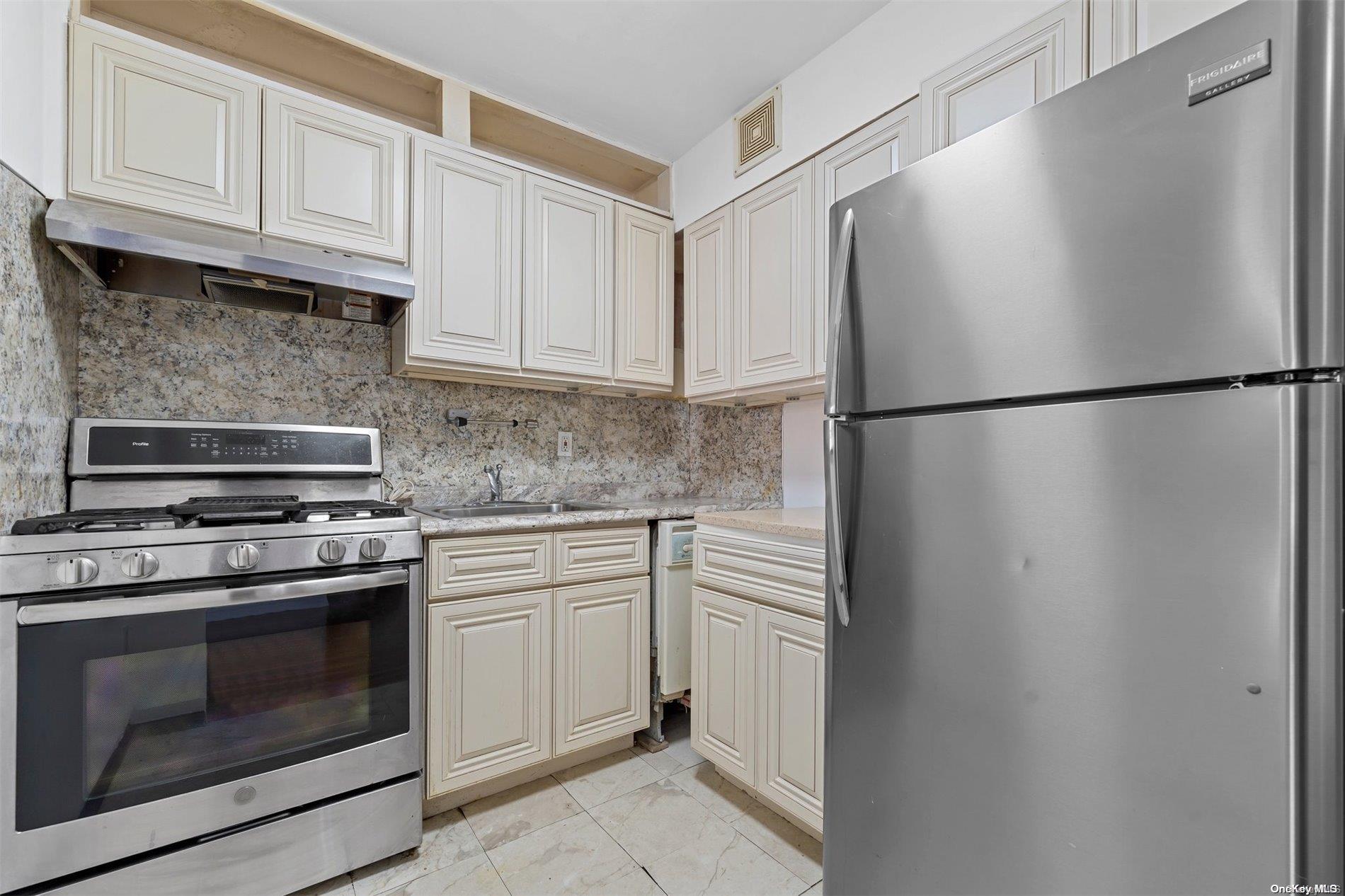 58-03 Calloway Street, Unit B3 Queens, NY 11368 - Photo 6 of 8 a kitchen with white cabinets and white stainless steel appliances