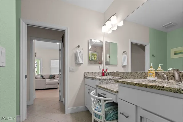 a en suite bathroom with a granite countertop sink and a mirror