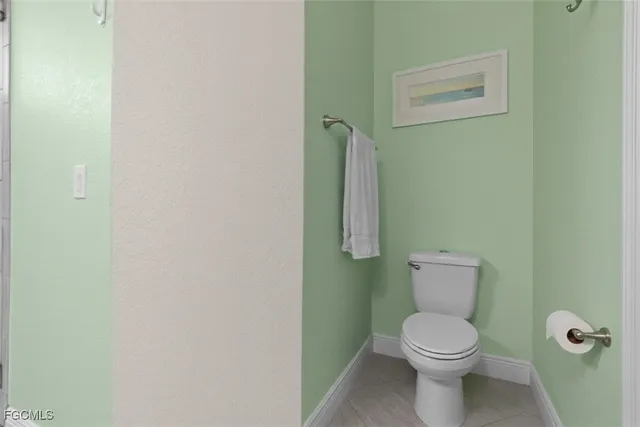 a white toilet sitting next to a white walls
