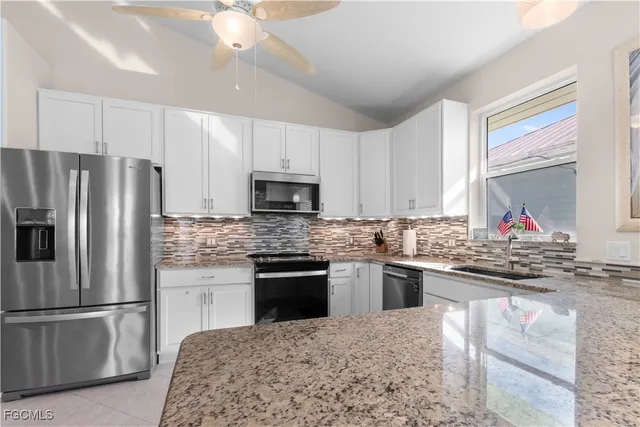 a kitchen with kitchen island granite countertop a stove sink and refrigerator