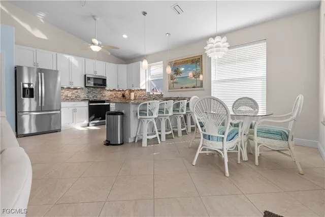 a kitchen with stainless steel appliances granite countertop a table and chairs in it