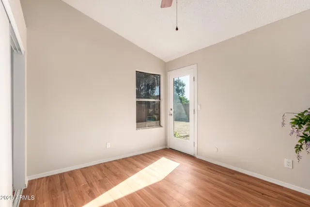 an empty room with wooden floor and windows