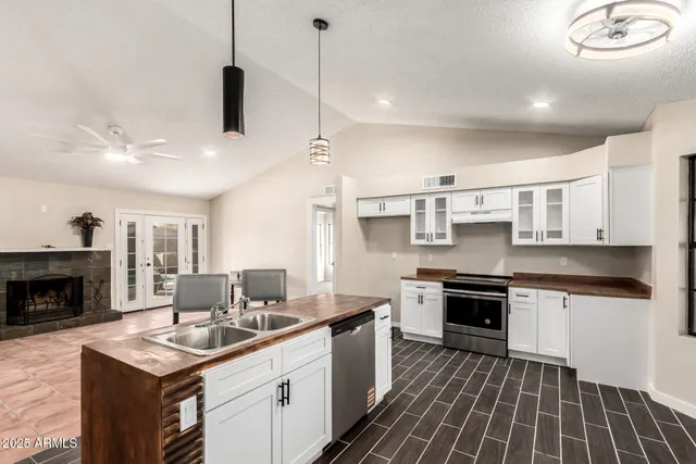 a kitchen with stainless steel appliances granite countertop a stove sink and cabinets