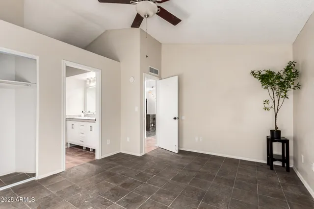 a view of a livingroom with a potted plant a ceiling fan and window