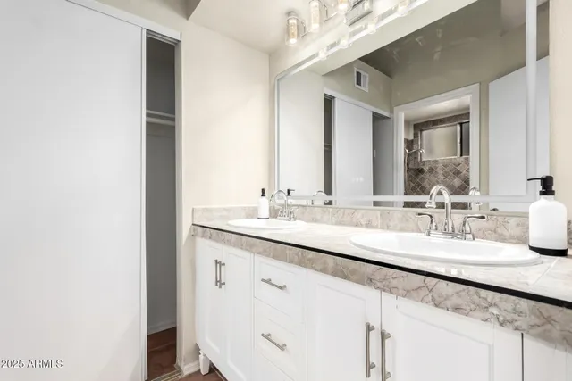 a bathroom with a double vanity sink and a mirror