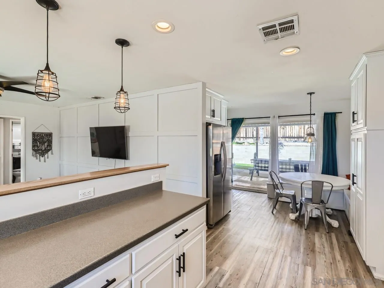 9456 Domer Road Santee, CA 92071 - Photo 11 of 30 a kitchen with stainless steel appliances a dining table chairs and a wooden floor