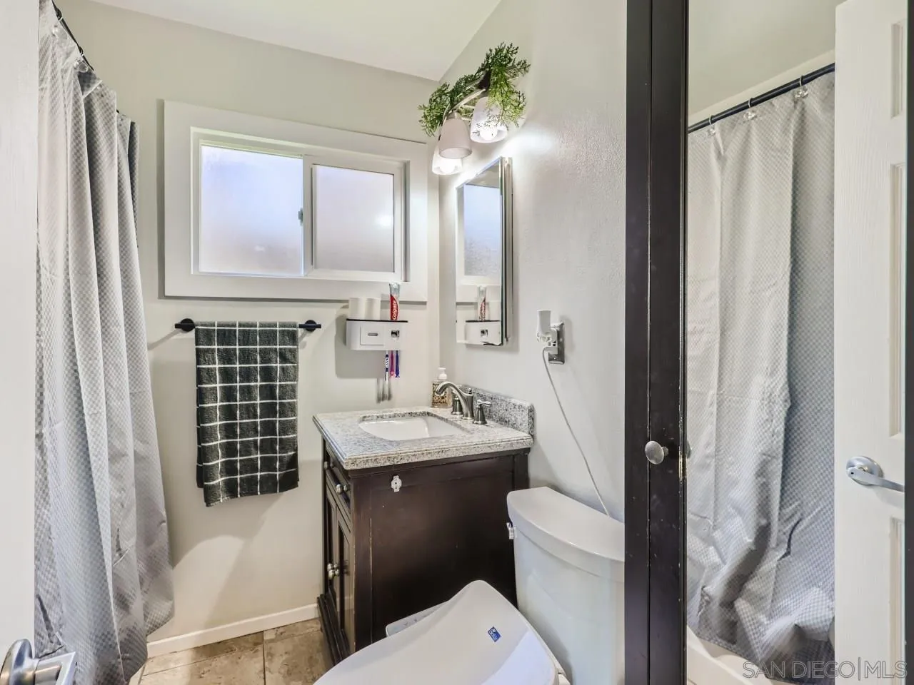 9456 Domer Road Santee, CA 92071 - Photo 17 of 30 a bathroom with a sink a toilet a mirror and shower