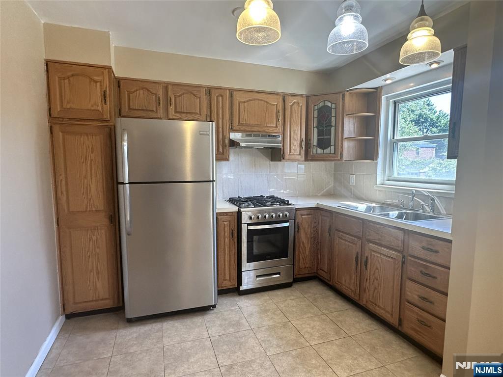 460 Heath Place, Unit 48 Hackensack, NJ 07601 - Photo 5 of 10 a kitchen with stainless steel appliances granite countertop a refrigerator sink and stove