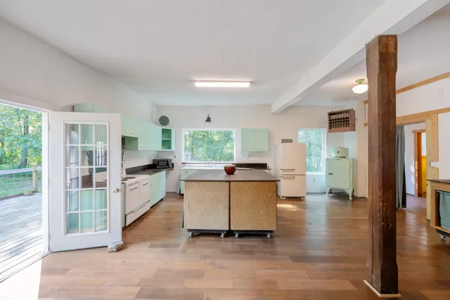 a bed sitting in a spacious bedroom next to a window