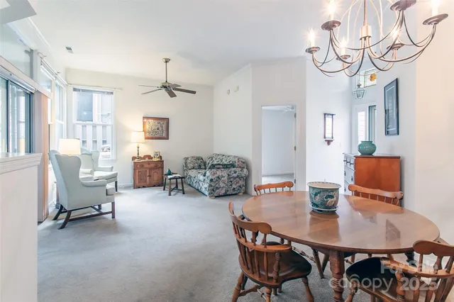 a dining room with wooden floor a chandelier a wooden table and chairs