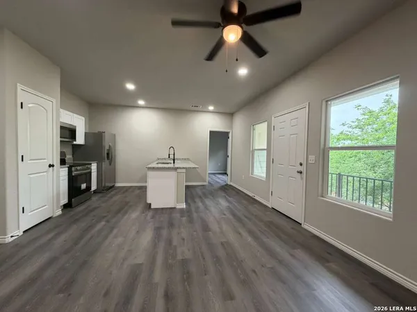 a view of kitchen with microwave a stove and wooden floor