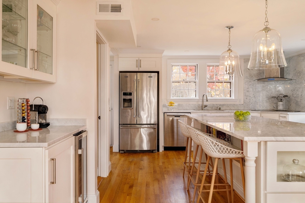 30 Prospect Street Winchester, MA 01890 - Photo 21 of 42 a kitchen with stainless steel appliances granite countertop a refrigerator a sink dishwasher a stove and a dining table with wooden floor