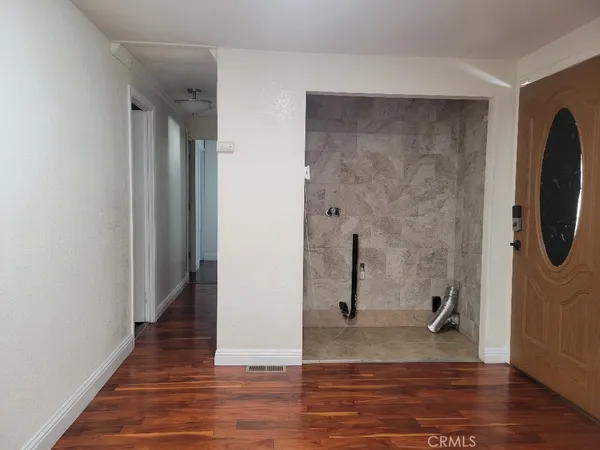 a view of kitchen with cabinets wooden floor and stainless steel appliances