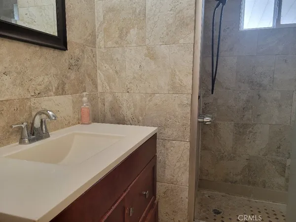a bathroom with a granite countertop sink toilet and shower
