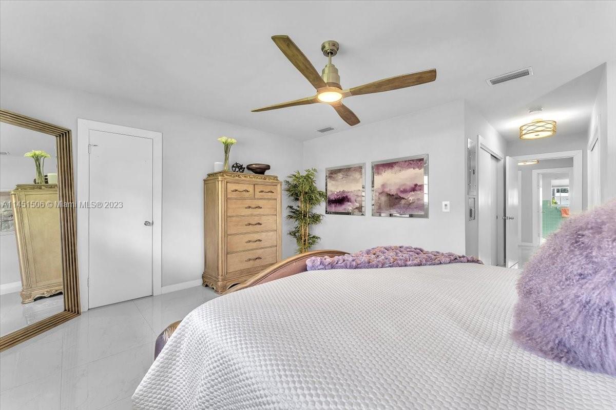 4103 Polk Street Hollywood, FL 33021 - Photo 26 of 55 a bedroom with a large bed and a chandelier