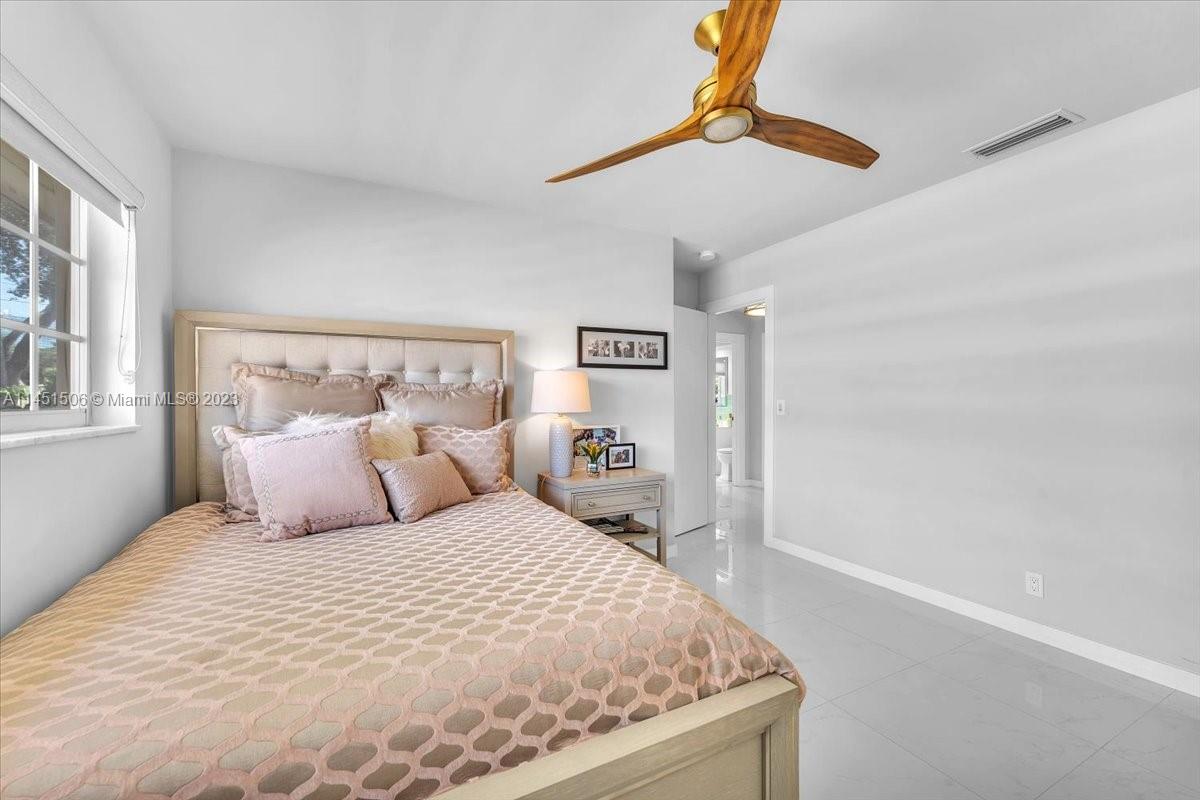 4103 Polk Street Hollywood, FL 33021 - Photo 31 of 55 a bedroom with a large bed and a chandelier