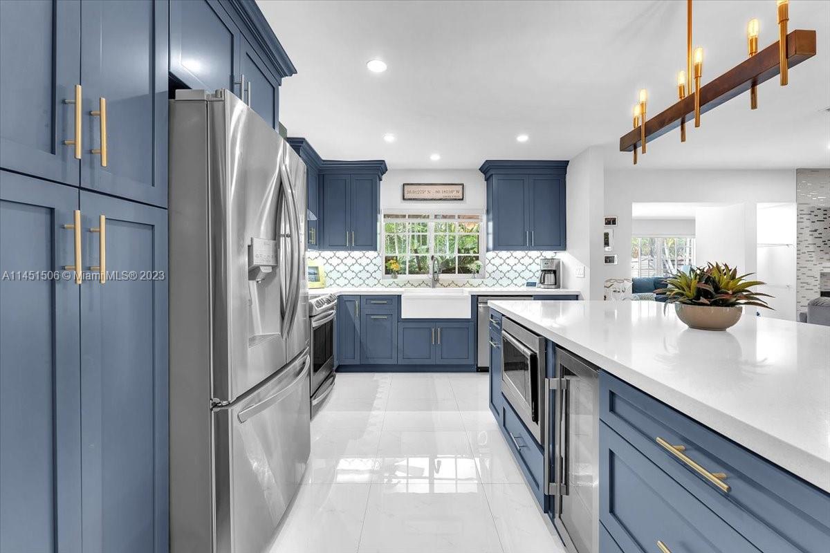 4103 Polk Street Hollywood, FL 33021 - Photo 7 of 55 a kitchen with stainless steel appliances a sink dishwasher a refrigerator and cabinets