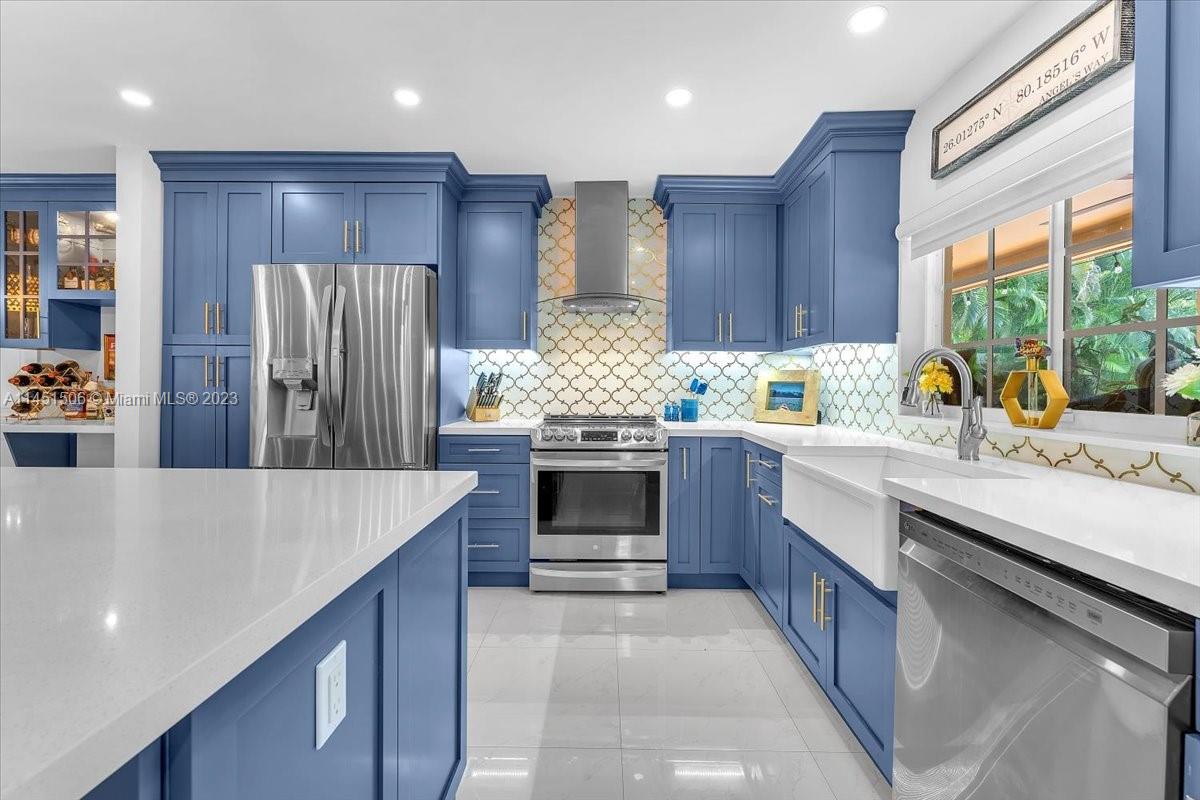 4103 Polk Street Hollywood, FL 33021 - Photo 10 of 55 a kitchen with stainless steel appliances kitchen island granite countertop a stove refrigerator and cabinets