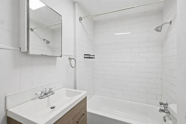a bathroom with a sink shower and a mirror