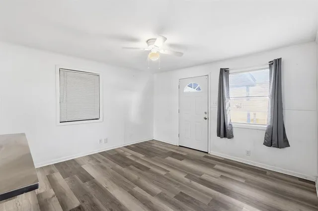 a view of empty room with window and ceiling fan