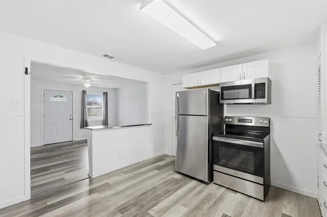 a kitchen with a refrigerator and a stove top oven