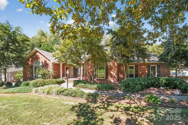 a front view of a house with a yard and trees