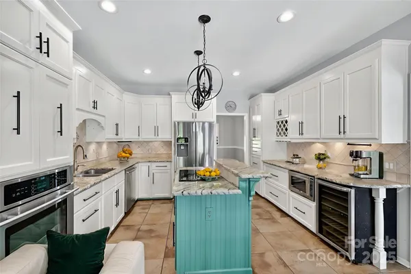 a kitchen with stainless steel appliances granite countertop a stove a sink dishwasher and a refrigerator