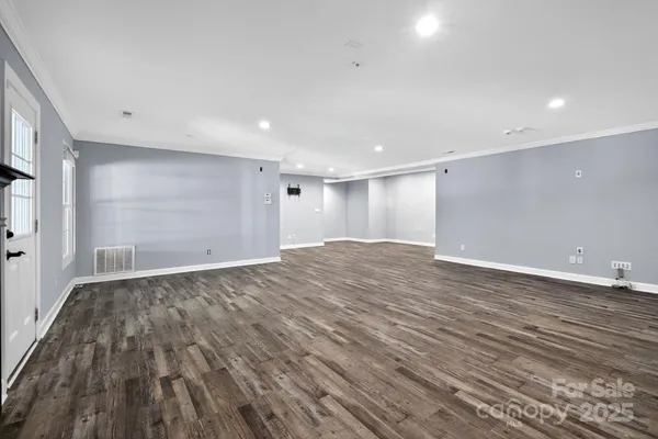 a view of empty room with wooden floor