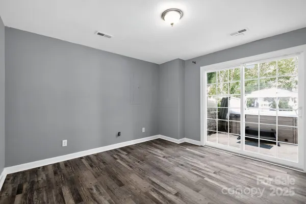a view of empty room with wooden floor and windows
