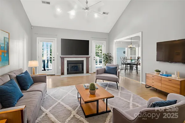 a living room with furniture a flat screen tv and a fireplace