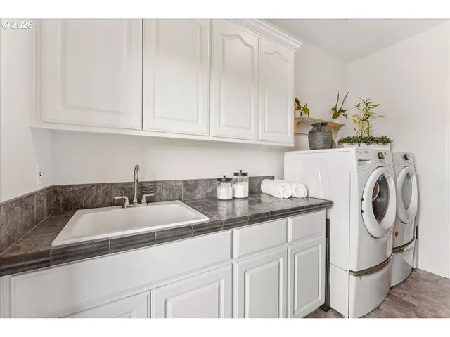 a kitchen with stainless steel appliances granite countertop a sink a stove and white cabinets