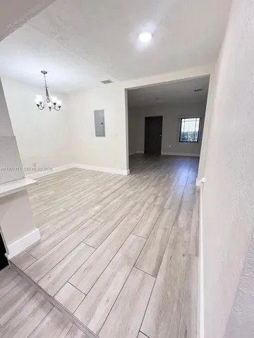 a view of an empty room and window and wooden floor