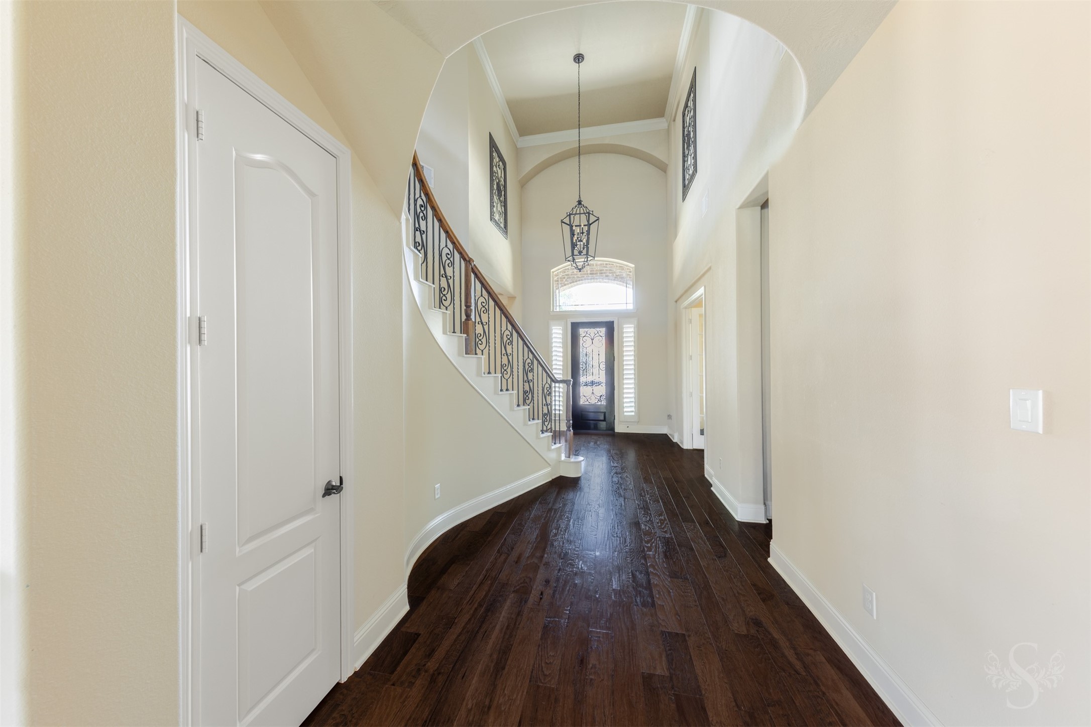 5803 Mustang Ridge Lane Fulshear, TX 77441 - Photo 2 of 48 Grand 2 story entry showcases rich wood flooring, soaring ceilings and a sweeping curved staircase with decorative iron balusters that creates a stunning first impression. Plantation shutters, crown molding and elegant architectural details add warmth and character throughout the home.