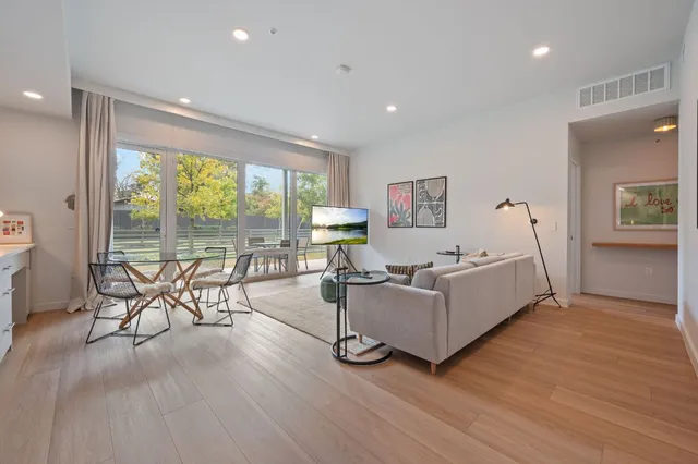 a living room with furniture and large windows