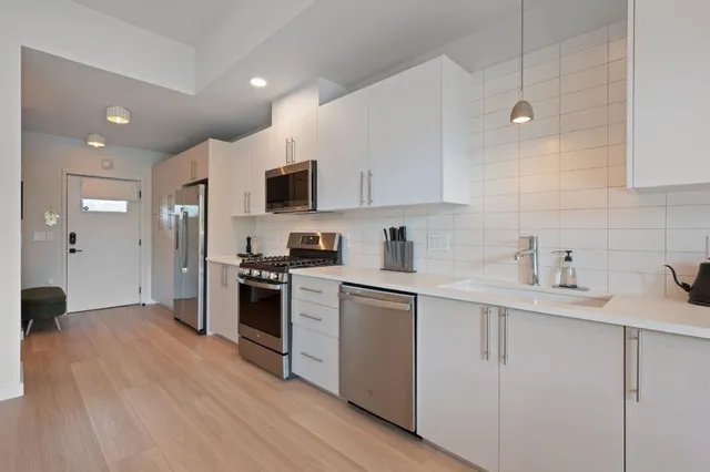 a kitchen with kitchen island a sink stainless steel appliances and cabinets