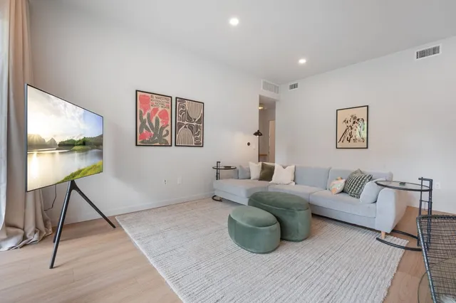 a living room with furniture and a wooden floor