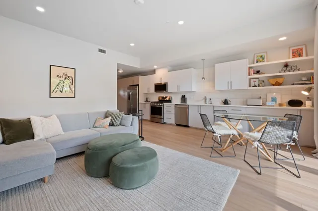 a living room with furniture and kitchen view