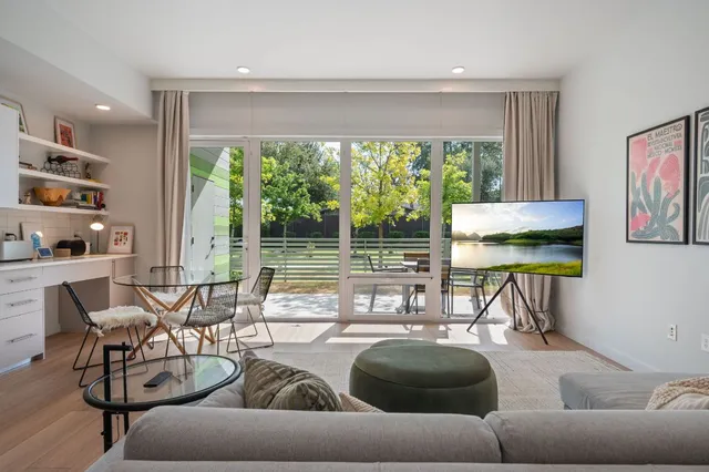 a living room with furniture and a floor to ceiling window